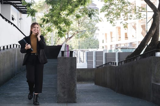 A woman is talking on her cell phone while walking down a stairway.