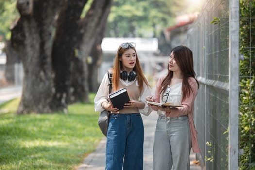 Group of young Asian college students are studying together in university. Students outdoors. Education concept..