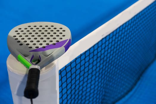 Black Paddle. Racket, balls an net in real court without logos. High quality photo