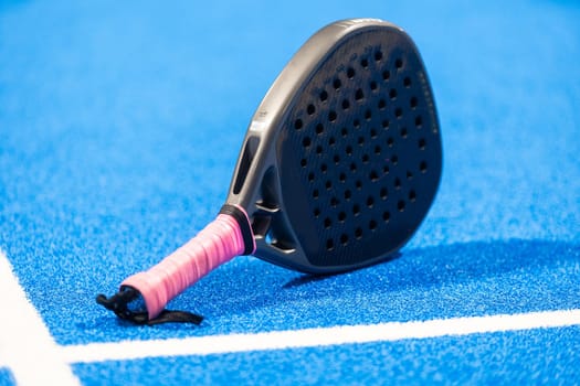 Paddle racket, next to the ball and on a carpet of the play area. High quality photo