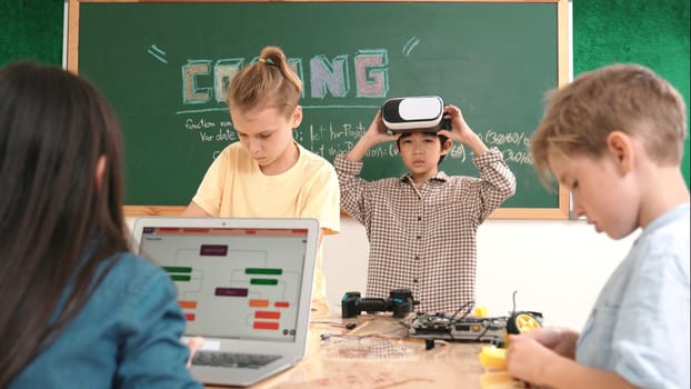 Energetic child wearing Vr headset while enter virtual world at classroom. Student programing system while generated AI to code engineering prompt software while boy fixing electronic board. Pedagogy.