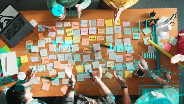 Top down view of business team with casual outfit looking laptop screen and sharing idea. Aerial view of manager works and checking color palette at table with statistic graph holographic. Symposium.