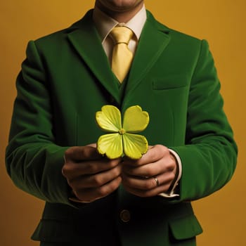 A man without a head or having in his hands a four-leaf large clover green suit, dark background.Green color symbol of St. Patrick's Day.A joyous time of celebration in green color.