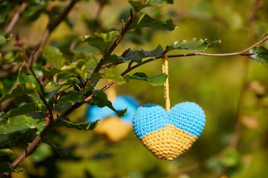 Knitted heart toys in the shape of the flag of Ukraine.