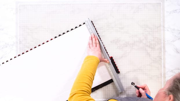 Flat lay. In the process of mounting peel and stick mosaic tiles onto a foam board, perfect for enhancing a food photography studio's aesthetic.