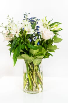 A stunning bouquet featuring fresh white roses and assorted flowers gracefully arranged in a vase, exuding timeless beauty.