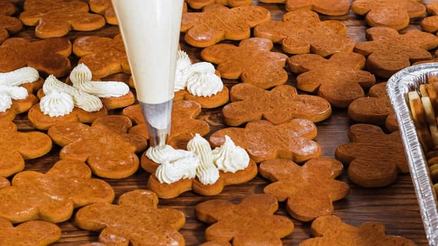 Crafting gingerbread cookie sandwiches with eggnog buttercream, presented on a rustic wooden table for Christmas gifting.