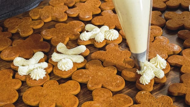 Crafting gingerbread cookie sandwiches with eggnog buttercream, presented on a rustic wooden table for Christmas gifting.