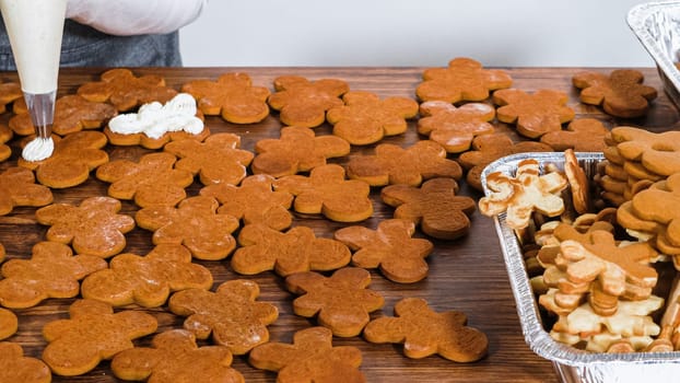 Crafting gingerbread cookie sandwiches with eggnog buttercream, presented on a rustic wooden table for Christmas gifting.