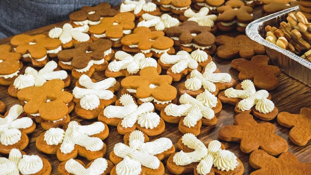 Crafting gingerbread cookie sandwiches with eggnog buttercream, presented on a rustic wooden table for Christmas gifting.