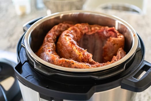 In a sleek modern kitchen, we are adding an extra layer of flavor to succulent baby back ribs by infusing them with a medley of spices in a multicooker-a mouthwatering feast in the making.