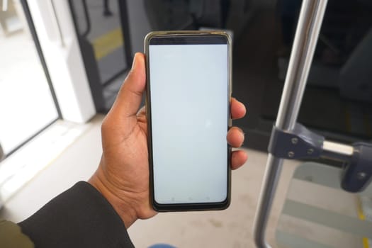 young man hand using smart phone with green screen inside of metro train ,