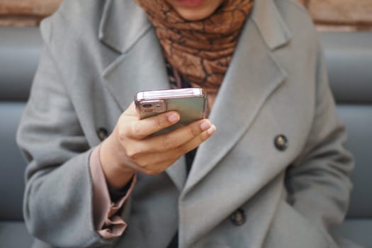 women hand holding smart phone sitting on cafe .