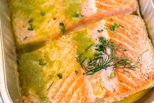 Discover the mouthwatering journey of salmon as it's cooked to perfection in an oven, nestled in a foil tray, adorned with rich butter and tantalizing spices.