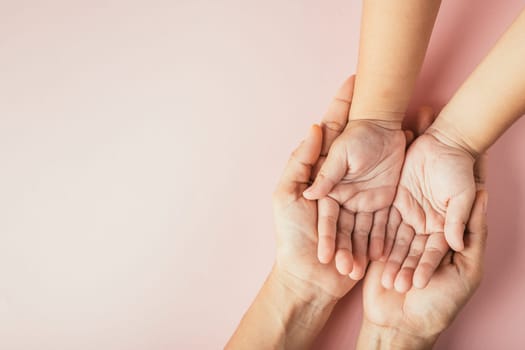 Top view of parents and kid holding empty hands together isolated on color background. Family day celebrating togetherness.