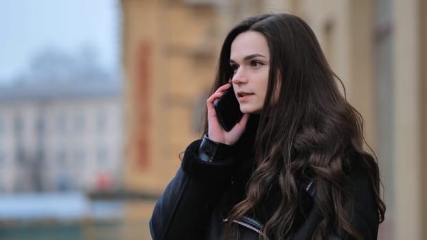 Beautiful stylish brunette girl talking on the phone on the street of her city