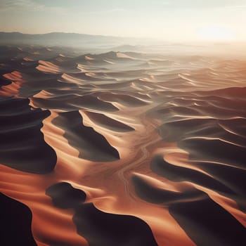 Aerial view of desert landscape with sand dunes and mountains at sunrise