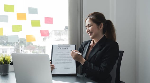 Asian woman working with graph data at office, financial report concept.