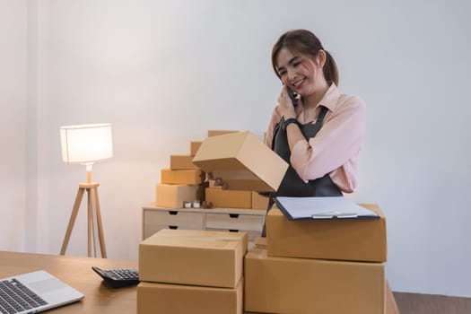 Startup small business entrepreneur SME, asian woman receive order on phone. Success young Asian small business owner home office, online sell marketing delivery.