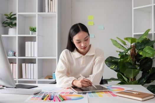 Female designer working in graphic design Choose colors for working on tablets and computer designs..