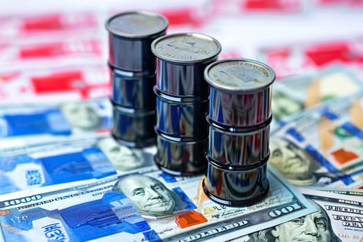 Black barrels of oil on dollar bills. The concept of enrichment using petroleum products. The concept of rising prices for oil and petroleum products.
