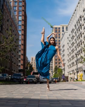 Beautiful Asian ballerina dancing outdoors. Urban landscape