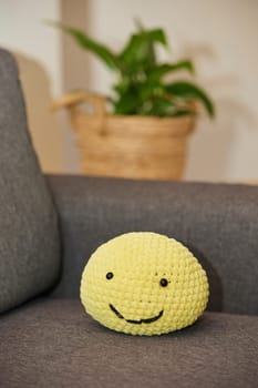 Cute soft knitted toy on the sofa.