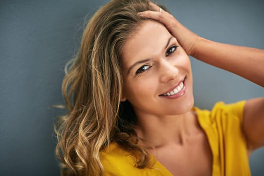 Portrait, smile and woman in studio for happiness, positive attitude or feel good mood on gray background. Face, confidence and person for relax, cheerful and chilling on weekend with dark backdrop.