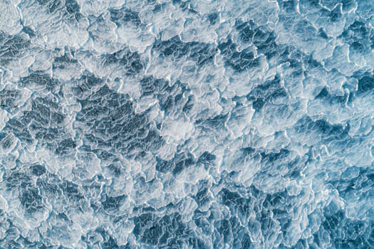 Aerial top down view of ice surface. Frozen sea surface texture