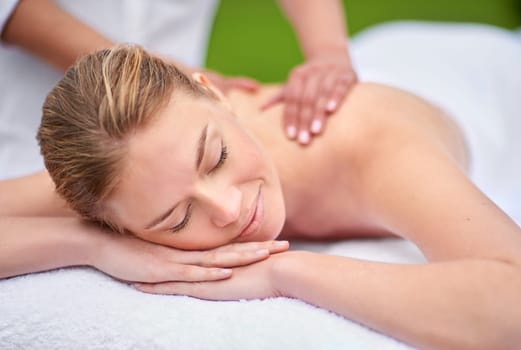 Massage, woman and spa for health, wellness and relaxation in muscles, back and neck for self care. Female person, physical therapy and detox for body with smile, calm and happiness on holiday.