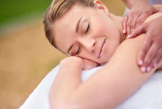Massage, woman and spa for therapy, wellness and relaxation in muscles, back and neck for self care. Female person, physical health and detox for body with smile, calm and happiness on holiday.