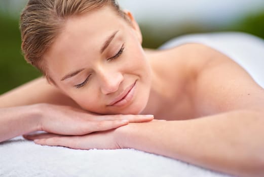 Massage, woman and spa for detox, wellness and relaxation in muscles, back and neck for self care. Female person, physical therapy and health for body with smile, calm and happiness on holiday.