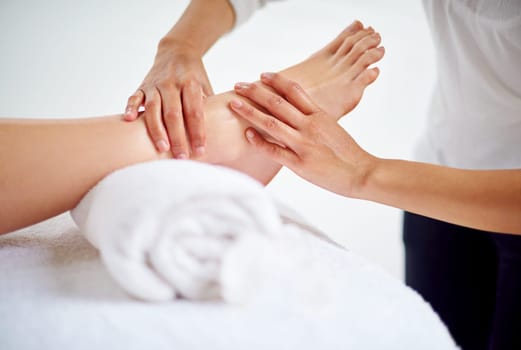Woman, feet and massage table in spa, therapy and self care for body wellness and resting for tension. Comfortable and resort with client, stress free and healing, calm session and cosmetology.