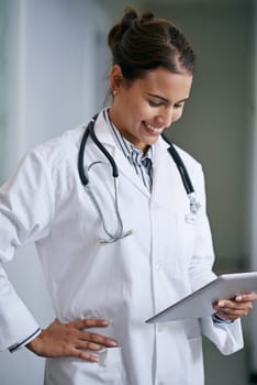Healthcare, happy and woman doctor with tablet for telehealth, research or online consultation in hospital. Smile, stethoscope and physician with technology for support, wellness and medical care.