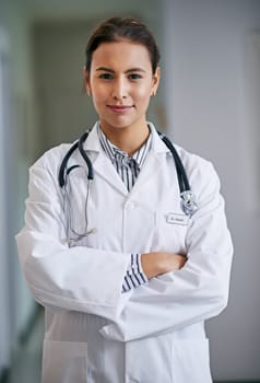 Woman, portrait and doctor with arms crossed in hospital, clinic and wellness facility with confidence in medical career. Female person, cardiologist and happy healthcare professional in Colombia.