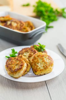 fried meat cutlets in a ceramic form on a wooden table .