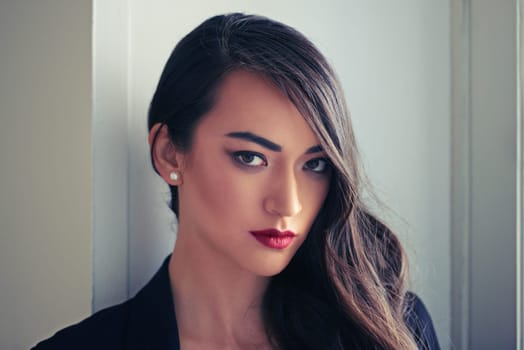 Woman, beauty and makeup in portrait with hair, confidence and pride in red lipstick for elegance and shine. Glamour, style and cosmetics, assertive and feminine with eyeliner for edgy look and waves.