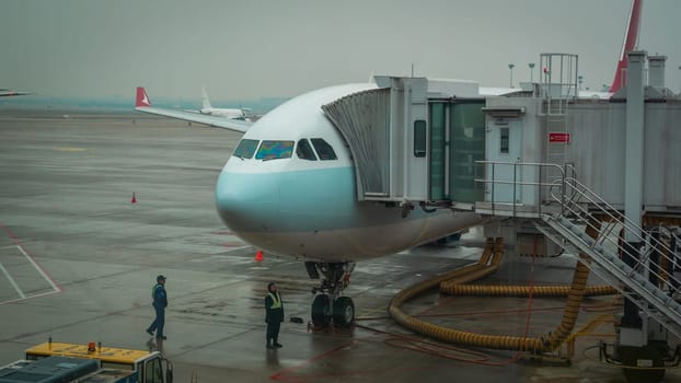 Airplane ready for boarding in Shanghai airport hub on rainy day
