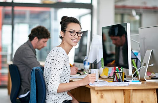 Portrait, woman and happy with notepad in office for career or job growth with opportunity. Employee, smile and satisfied with pride as graphic designer with computer, desk and notes for training.