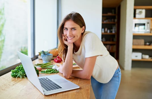 Cooking, home and woman with food, laptop and vegetable lunch for online search. Diet, wellness and girl at kitchen counter with website for recipe research, ingredients and nutrition for gut health.