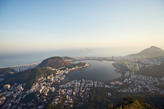 City, ocean and blue sky with vacation, drone and Rio De Janeiro for summer holiday, urban town and aerial view. Landscape, location and beach with buildings, getaway trip and mountains with sunshine.