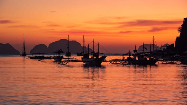 Beautiful sunset with silhouettes of philippine boats in El Nido, Palawan island, Philippines