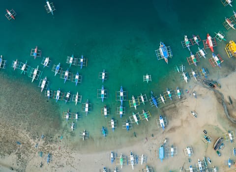 Aerial drone view of boats anchored in the bay with clear and turquoise water. Boats and yachts in the tropical lagoon. Tropical landscape.