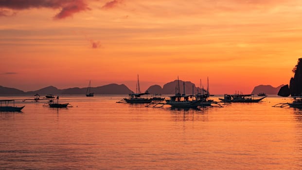 Beautiful sunset with silhouettes of philippine boats in El Nido, Palawan island, Philippines