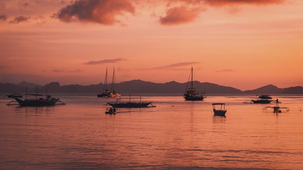 Beautiful sunset with silhouettes of philippine boats in El Nido, Palawan island, Philippines