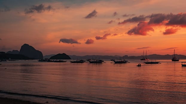 Beautiful sunset with silhouettes of philippine boats in El Nido, Palawan island, Philippines