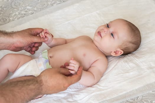 Father focuses on providing a calming massage to his infant promoting health and bonding