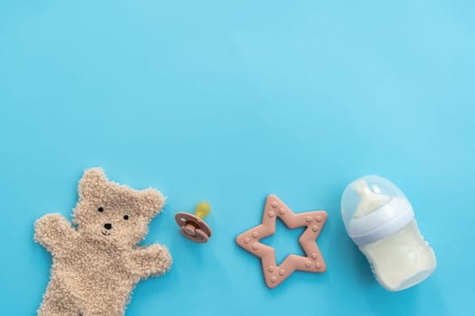 An array of infant accessories artfully arranged on a tranquil blue backdrop, top view offering