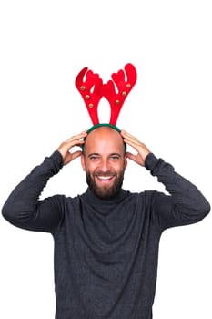 Smiling young caucasian man with Christmas reindeer antlers looking at camera. Isolated on white background. Vertical image. Holiday concept.