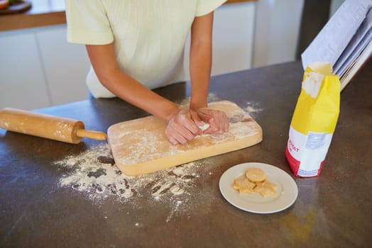 Baking, home and hands of woman with cookie dough, flour and homemade food for lunch. Diet, wellness and person at kitchen counter with ingredients, nutrition and recipe book for biscuits on board.